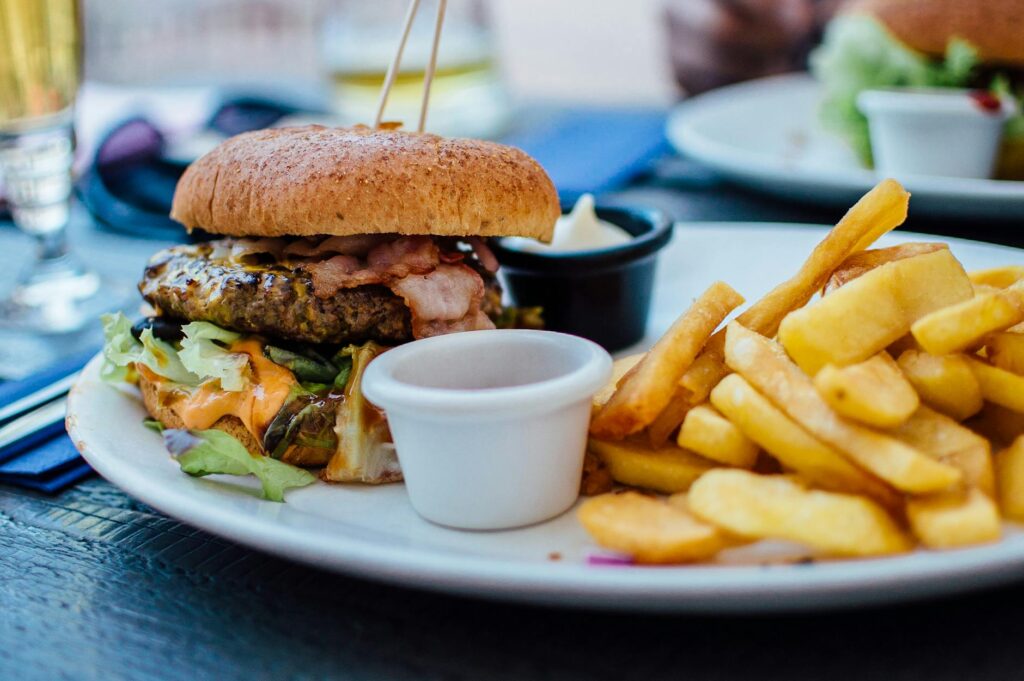 Top 5 Harmful Foods in Our Daily Diet and Their Long-Term Health Impact fries and burger on plate